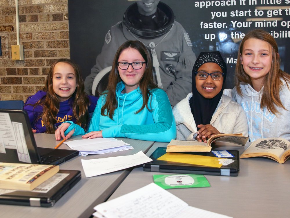 Four students work on homework at a table