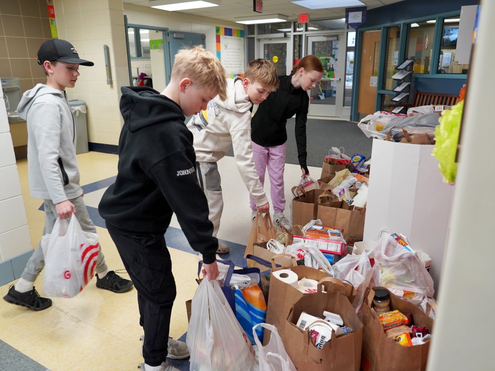 students dropping off bags of donated food