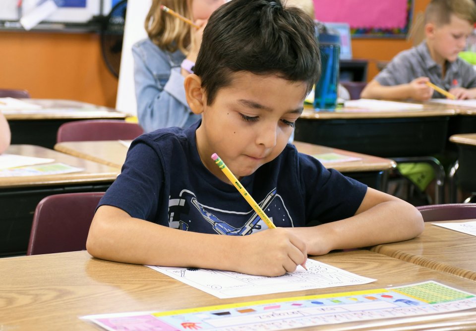 A student writes at his desk
