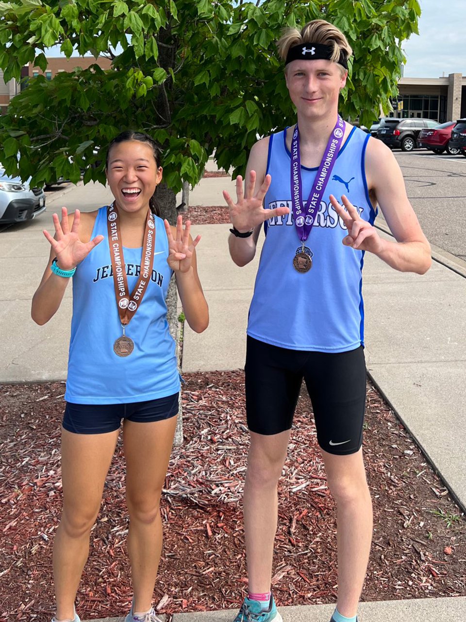 female and male track and field athletes with medals