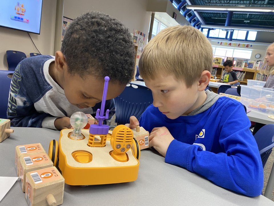two boys program robotic