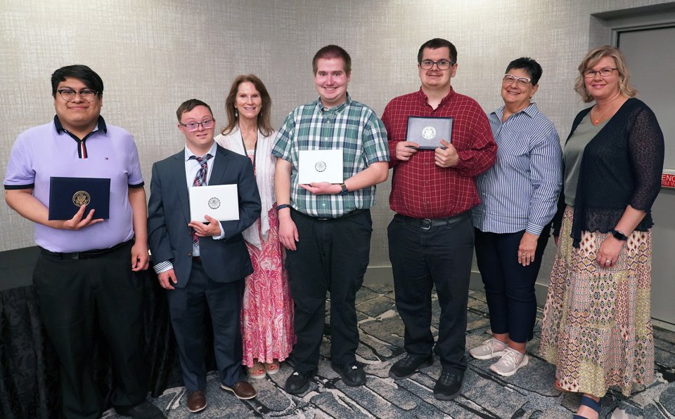 four adult students with their diplomas