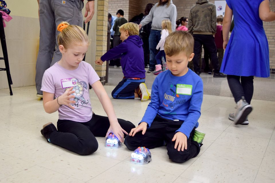 two students playing with programmed robots