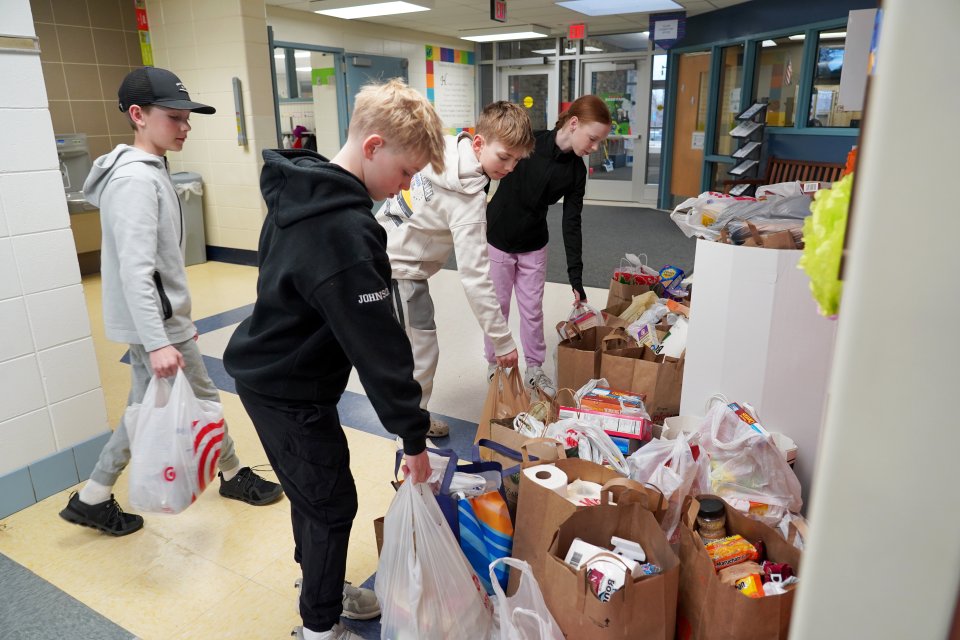 students dropping off bags of donated food