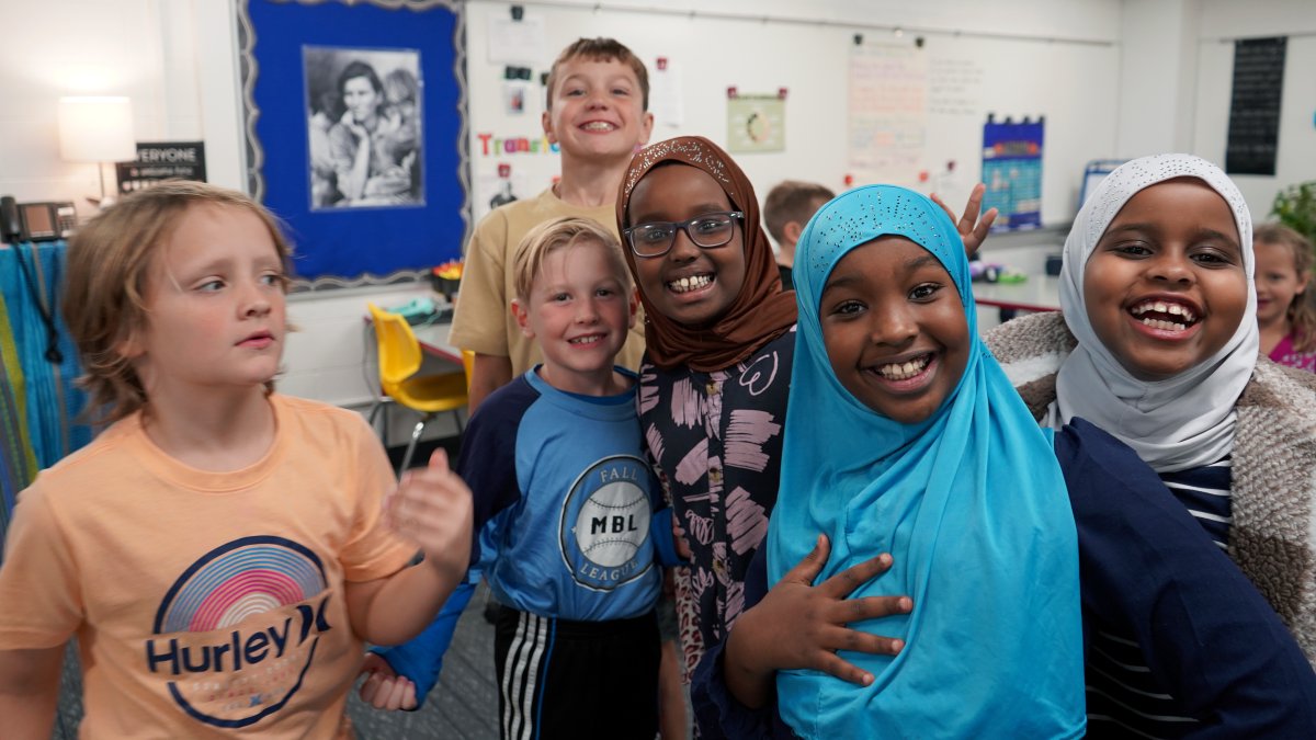 six students smiling in classroom