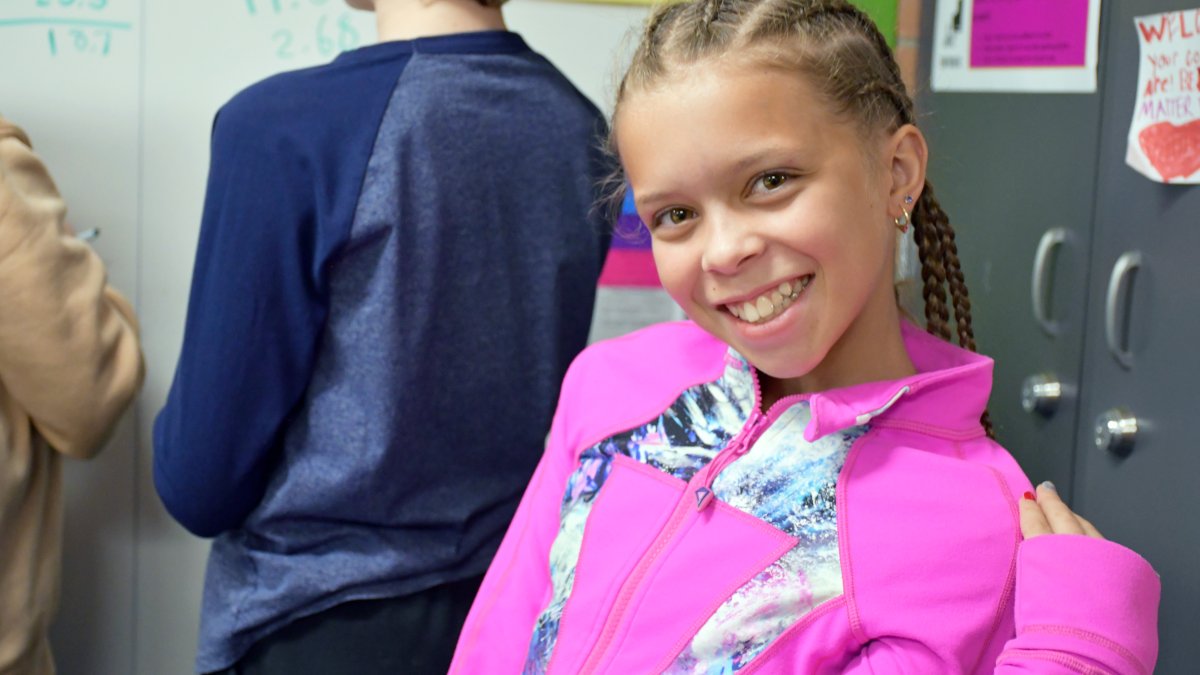 student wearing a pink jacket smiling