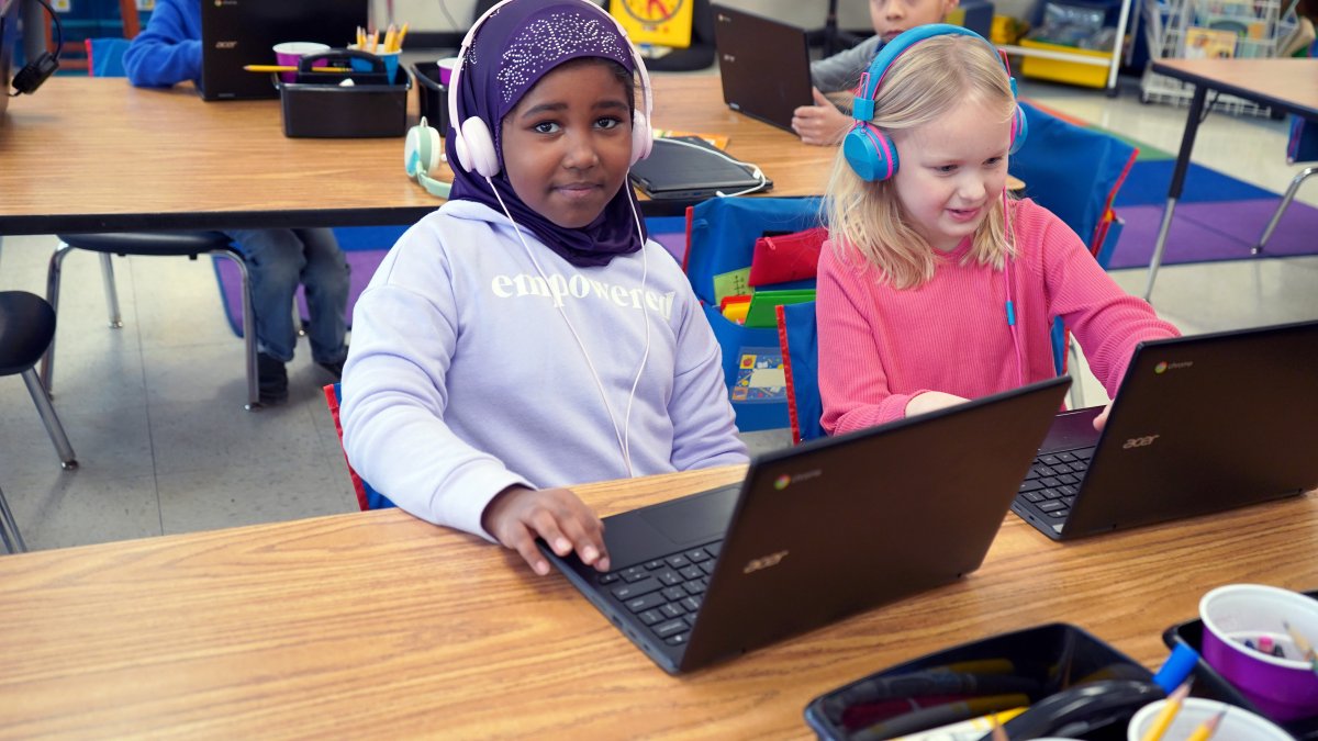 two girls using laptops