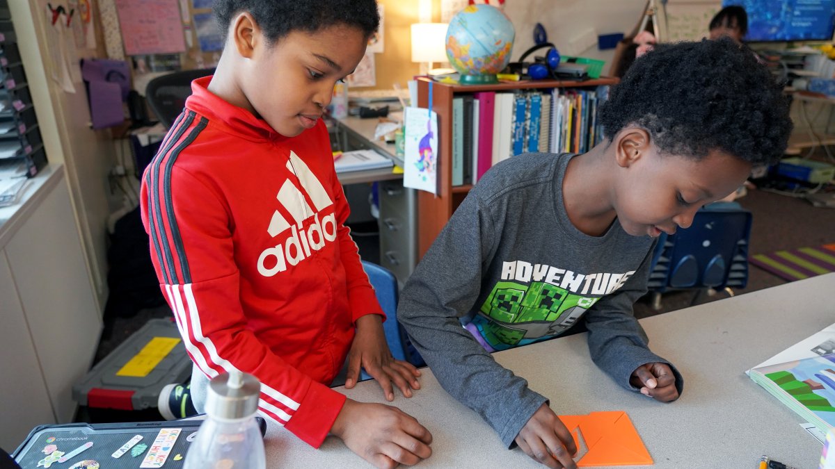 two boys working on a tangram