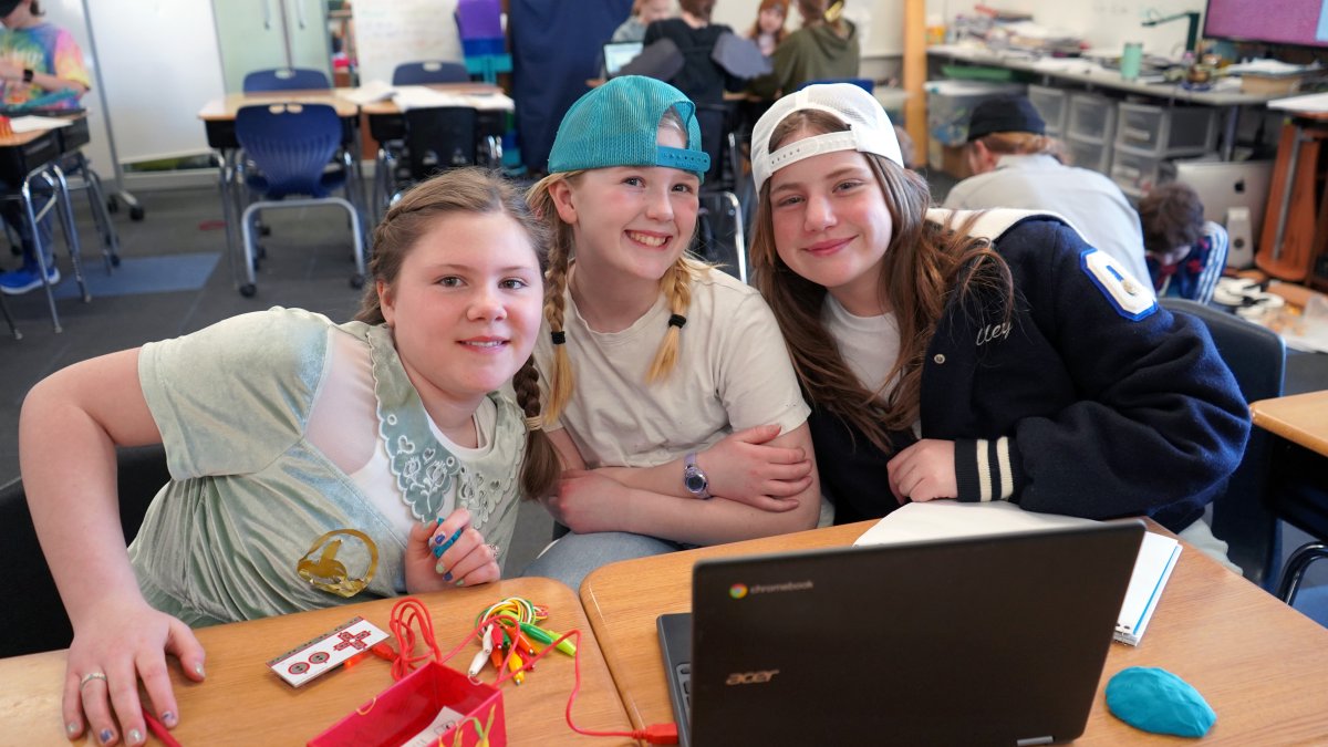students smiling with laptop and electronics