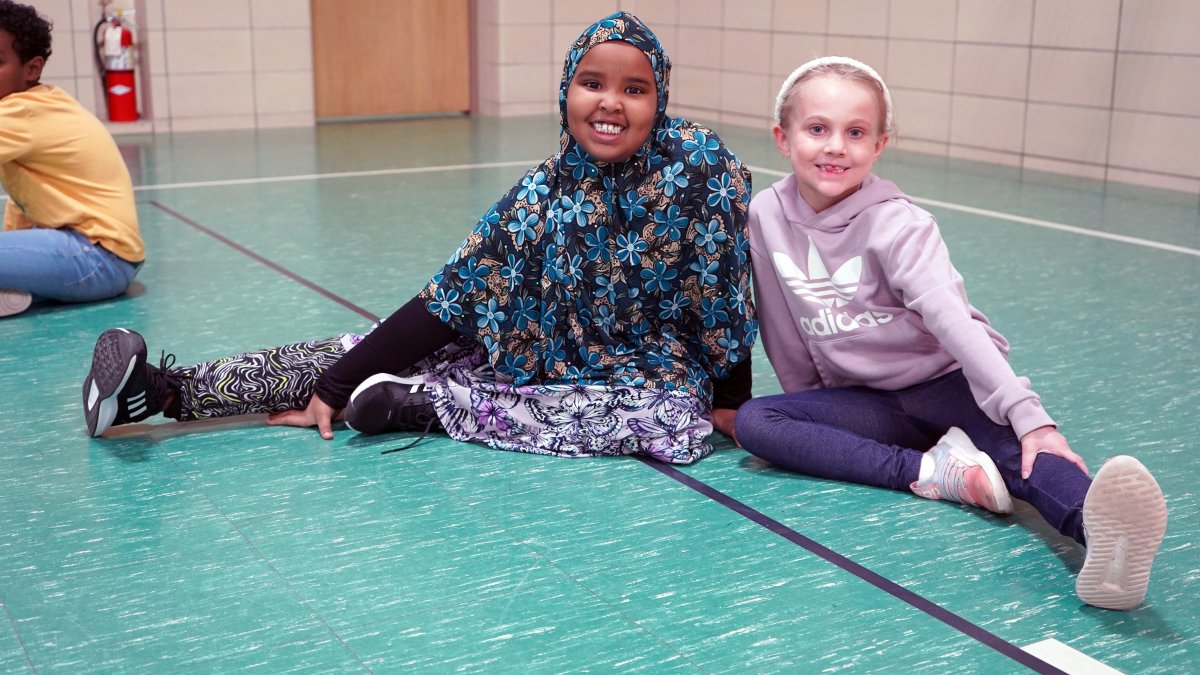 students sitting on gymnasium floor