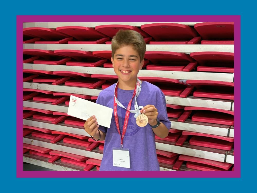 Boy holding a third place award medal