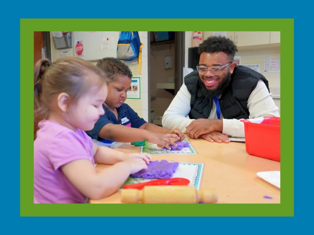 Paraprofessional working with two preschool students.