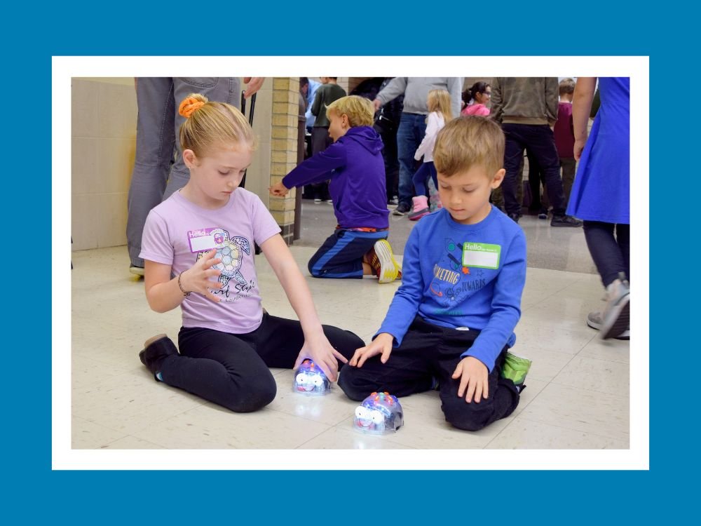 two students playing with programmable robots