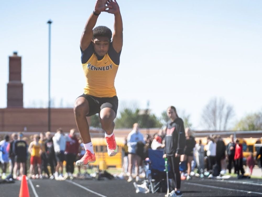 track and field athlete in mid-air during the triple jump