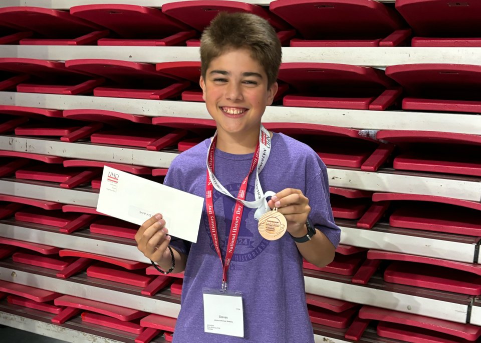 boy holding third place award medal