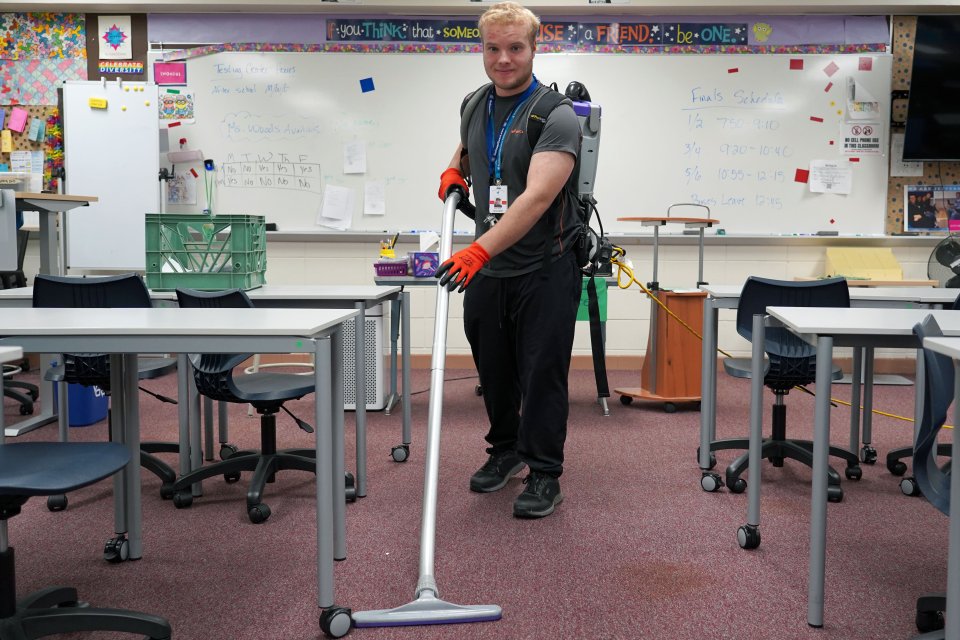 Adam Rich, a custodian, vacuuming a classroom