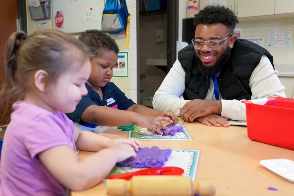 Martavis Robinson working as a paraprofessional with two preschool students