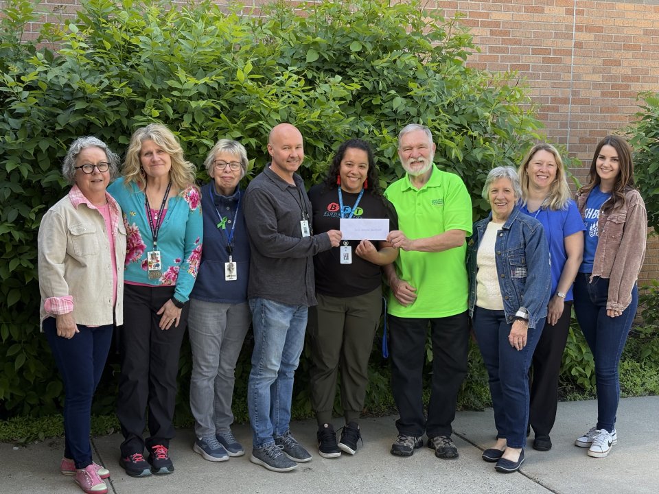 educators in front of a tree accepting an award